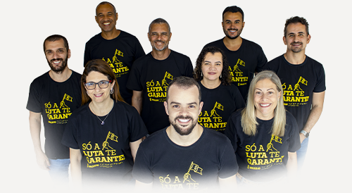 Foto de servidores e servidoras vestindo camisetas com o lettering Só a Luta te Garante do SINJUS-MG